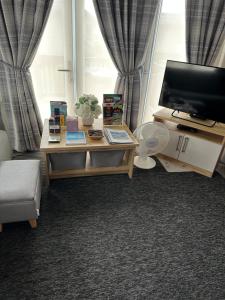a living room with a tv and a coffee table at Duckpool 108 Bude in Bude