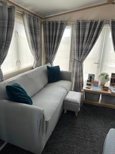 a living room with a couch and two windows at Duckpool 108 Bude in Bude