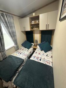 a small room with two beds and a window at Duckpool 108 Bude in Bude