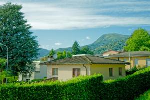 a house in a vineyard with mountains in the background at La Locanda del Gusto in Cadro