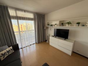 a living room with a flat screen tv on a dresser at Las Arenas Playa del Ingles Apartment 413 in San Bartolomé