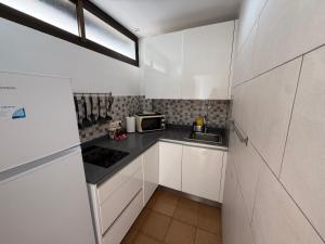 a small kitchen with white cabinets and a sink at Las Arenas Playa del Ingles Apartment 413 in San Bartolomé
