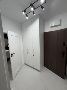 a room with white cabinets and a brown door at MC Residence Łomża in Łomża