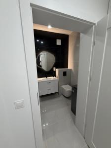 a bathroom with a sink and a toilet and a mirror at MC Residence Łomża in Łomża +3 photos