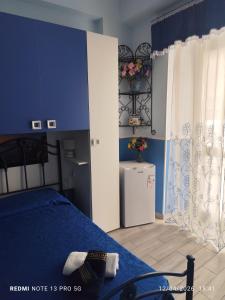 a bedroom with a bed and a blue wall at Da zio Michele in Scilla