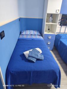 a bedroom with a blue bed with towels on it at Da zio Michele in Scilla