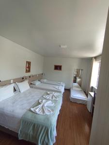 a room with three beds and a window at Pousada Casarão Schmidt in Pomerode +43 photos