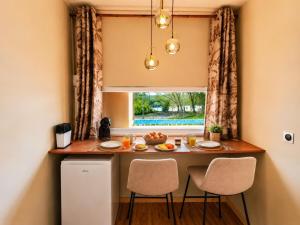 a kitchen with a table with chairs and a window at Tropical Chic Studio - Marina View - Swimming Pool in Les Trois-Îlets +7 photos