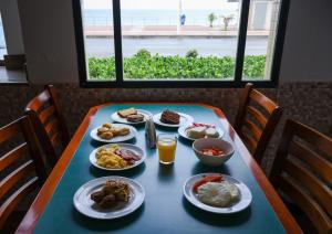 a table with plates of food and drinks on it at Portobello Pituba Praia in Salvador