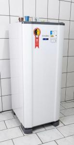 a white refrigerator sitting on a tiled floor at Casa no Centro Vilhena in Vilhena