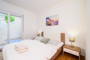 a white bedroom with a large bed and a window at Holiday Home in Komarna