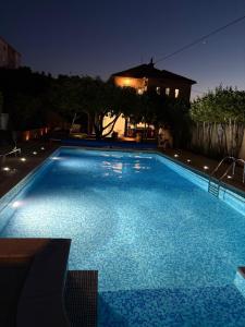 a large swimming pool at night with a house at Villa Bakica in Trogir