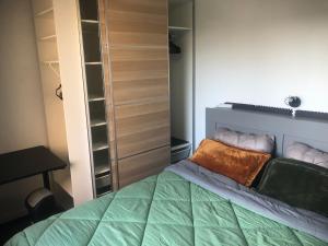 a bedroom with a bed with a green bedspread at Near Paris in Ris-Orangis
