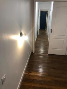 a hallway with a light on the wall and a door at Near Paris in Ris-Orangis