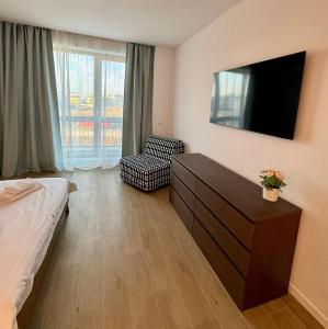 a bedroom with a bed and a tv and a chair at MAYA Studio-Onix Blue with Private Parking, Mamaia Nord in Mamaia Sat/Năvodari
