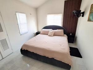 a bedroom with a bed with pink pillows on it at Discovery Bay Villa and Beach Club in Discovery Bay