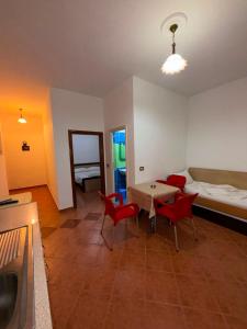 a living room with a table and chairs and a bed at Rajan Rooms in Vlorë