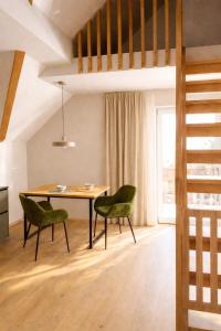 a dining room with a table and two green chairs at Riolina Suite in Mühlbach