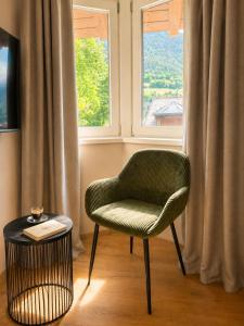 a green chair sitting in front of a window at Riolina Suite in Mühlbach