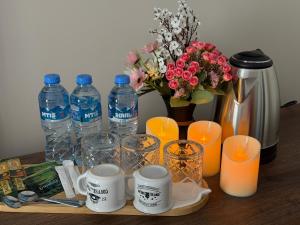 a table with bottles of water and a vase with flowers at SkyHouse Batumi in Batumi