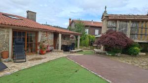 a house with a patio and a yard with grass at Cabana Toxosoutos in Tojos Outos