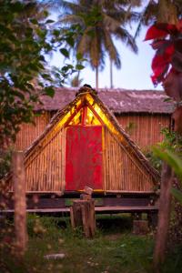 een huis met een rode deur met lichten erop bij Tampat do Aman in Kudat