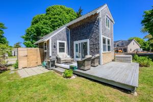 a small house with a wooden deck in a yard at Cape Cod Cottage near Beaches & Downtown in Chatham
