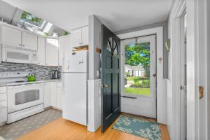 a kitchen with white cabinets and a white refrigerator at Cape Cod Cottage near Beaches & Downtown in Chatham