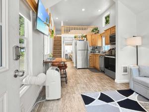 a kitchen and living room with a refrigerator and a table at Lake Sutherland Chalet Tiny home with lake access in Port Angeles