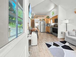 a kitchen and living room with a couch and a table at Lake Sutherland Chalet Tiny home with lake access in Port Angeles