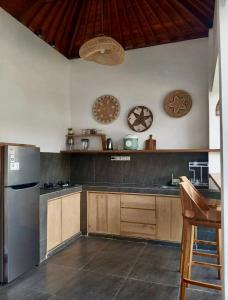 a kitchen with wooden cabinets and a stainless steel refrigerator at SinCity Nature Private Pool Villa in Tanjung