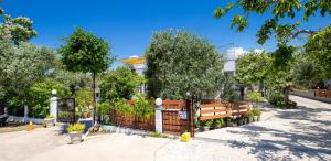 a fence in a park with trees and a building at Studios Panagiotas House Astris in Astris