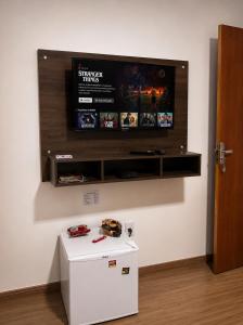 a flat screen tv on a wall above a white refrigerator at Hotel Via Center in Divino +13 photos