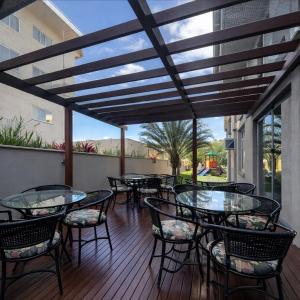 a patio with tables and chairs on a deck at Pousada Casarão Schmidt in Pomerode