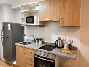 a kitchen with a sink and a refrigerator at Alto Arrayán II in Osorno