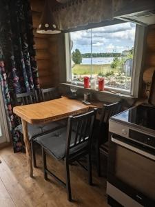 a kitchen with a wooden table and chairs and a window at Cozy Lakeside Adventure - Biberburg am See in Osby