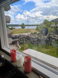 a window with a view of a stone wall at Cozy Lakeside Adventure - Biberburg am See in Osby