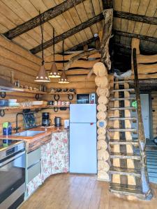 a kitchen with a refrigerator and a staircase at Cozy Lakeside Adventure - Biberburg am See in Osby
