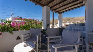 a patio with chairs and tables and flowers at Marousω's Μaisonette in Dhragoulás