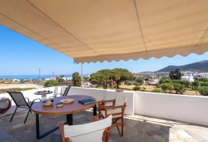 a patio with a table and chairs on a balcony at Flo Guest House in Sifnos