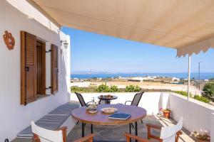 a table on a balcony with a view of the ocean at Flo Guest House in Sifnos