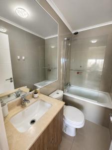 a bathroom with a sink and a toilet and a tub at Alto Arrayán II in Osorno