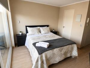 a bedroom with a bed with a towel on it at Alto Arrayán II in Osorno