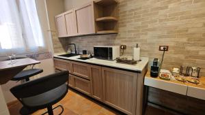 a kitchen with a counter with a microwave and a chair at Montefiori Luxury Suite & Spa in Bologna