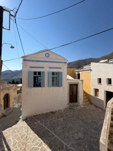 a white house with a window and a door at Marthas Traditional House in Symi