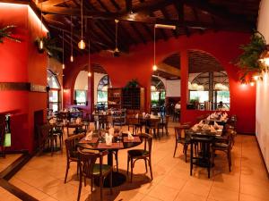 a restaurant with tables and chairs and red walls at Marcopolo Suites Iguazu in Puerto Iguazú