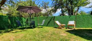 a fence with a table and chairs and an umbrella at Villetta Sioni in Sioni