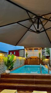 a swimming pool with a large umbrella over it at SkyHouse Batumi in Batumi