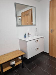 a bathroom with a white sink and a mirror at Ferienwohnung Lolek in Brilon +30 photos