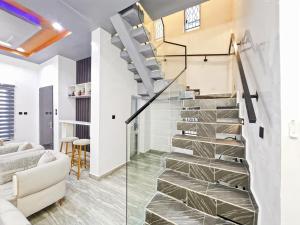 a winding staircase in a living room with a glass wall at Domina Apartment in Kubwa